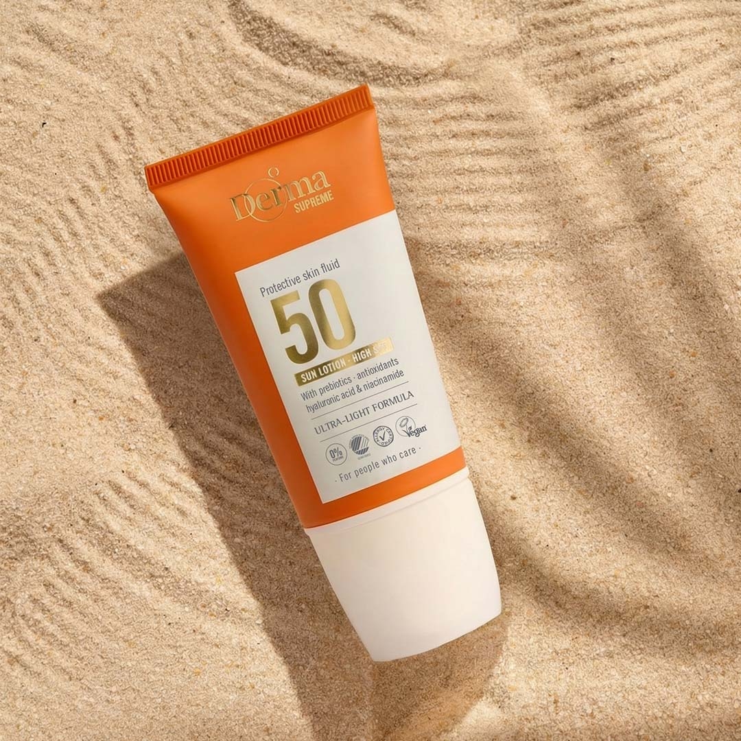 Derma Supreme Fluid Ansigtssolcreme SPF50 i sand med skygge fra palme